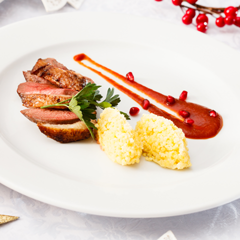 Petto d’anatra arrosto con quenelle di miglio bollito e salsa di melagrana